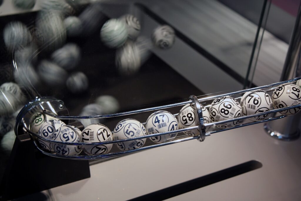 Weiß-schwarze Lotteriekugeln in einer transparenten Röhre während einer Ziehung.