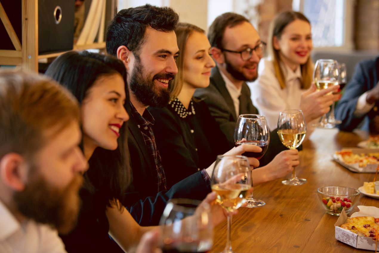 Team bei Firmenfeier NRW beim Anstossen mit Wein in gemuetlicher, stilvoller Umgebung